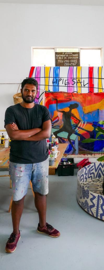Evan Sohun dans son atelier à Maurice. A droite de la photo une sculpture de son personnage Toudim. © Crédits Artskop3437